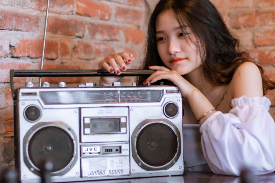 young Asian lady listening to a boombox