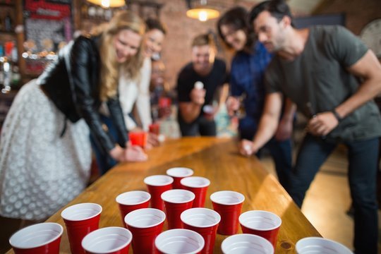 Friends playing bong pong in a social setting